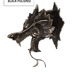 May include: Black polished dragon head wall mount sculpture with gold accents. The dragon has a fierce expression with sharp teeth and claws.