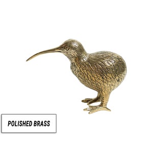 May include: A polished brass sculpture of a kiwi bird. The bird is standing on its two legs with its beak pointing forward. The sculpture is detailed with feathers and has a realistic appearance.