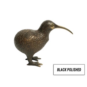 May include: A bronze sculpture of a kiwi bird with a black polished finish. The bird is standing on its feet with its head turned to the side and its beak pointing forward.