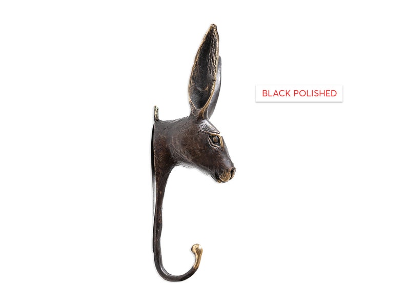 May include: Black polished bronze rabbit head wall hook. The hook is shaped like a rabbit's head with long ears and a curved hook for hanging items.