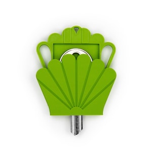May include: A bright lime green plastic key cover shaped like a stylized shell or fan with a small hole at the top for a keychain. The cover features a decorative scalloped edge and two side handles, partially enclosing a silver metal key blade.