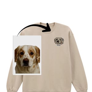 Könnte beinhalten: Beiges Sweatshirt mit einer Hundeillustration auf der oberen rechten Brust, darunter der Name "Latte". Auf der linken Seite ist ein Bild des Hundes zu sehen. Das Sweatshirt hat lange Ärmel und einen Rundhalsausschnitt.