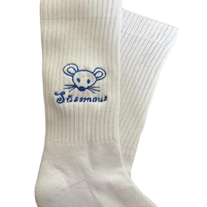 May include: A pair of white ribbed socks with a blue embroidered mouse design and the word "S&uuml;ssmaus". The socks are made of a soft, comfortable material.