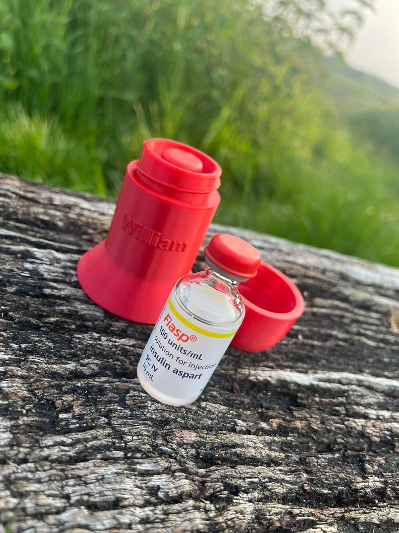 Peut inclure: Un r&eacute;cipient en plastique rouge avec le mot "William" imprim&eacute; dessus. Un flacon en verre transparent avec un bouchon rouge est pos&eacute; sur le r&eacute;cipient. Le flacon est &eacute;tiquet&eacute; "Fiasp&reg; 100 unit&eacute;s/mL insuline aspart solution injectable SC, IV 10 mL".