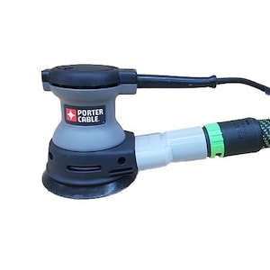 May include: A gray and black Porter Cable sander with a green and black hose attachment. The sander has a dust collection port and a trigger switch.