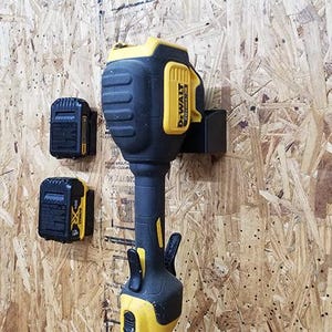 May include: A yellow and black DeWalt 20V MAX cordless string trimmer with two black DeWalt 20V MAX batteries mounted on a wall.