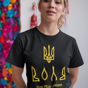 May include: A black t-shirt with a yellow Ukrainian trident and the word "BOЛЯ" (Volia - Freedom) printed on the front.