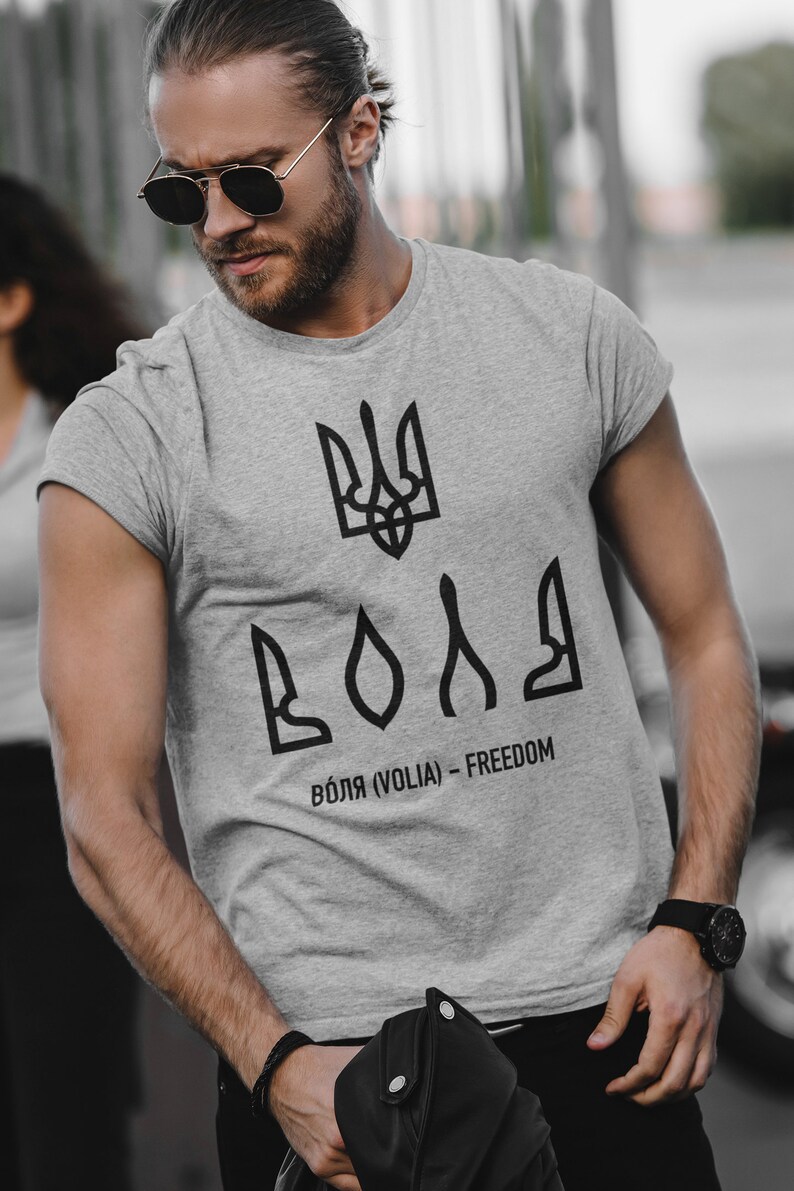 May include: A gray t-shirt with a black Ukrainian trident symbol and the word "ВОЛЯ" (VOLIA) - FREEDOM printed on the front.