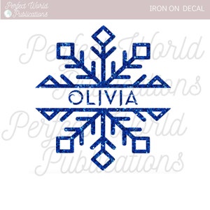 May include: Blue glitter snowflake iron-on decal with the name "Olivia" in the center.