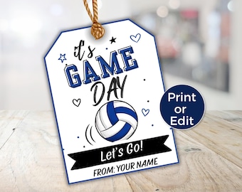 May include: A white rectangular gift tag with blue borders and a brown string. The text reads "it's GAME DAY" in blue and black, with a blue and white volleyball graphic, a black banner with "Let's Go!" in white, and "FROM: YOUR NAME" at the bottom.