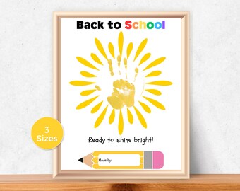 May include: Framed print with the text "Back to School" in colorful letters. A yellow handprint is at the center, surrounded by yellow sun rays. The text "Ready to shine bright!" is below the handprint, with a pencil graphic.