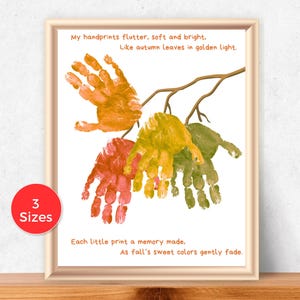Puede incluir: Impresión artística enmarcada con huellas de manos coloridas que se asemejan a hojas de otoño. El texto dice: "Mis huellas revolotean, suaves y brillantes. Como hojas de otoño en luz dorada. Cada pequeña huella, un recuerdo hecho." Un círculo rojo indica "3 Tamaños".
