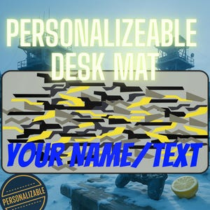 May include: A rectangular desk mat with a camouflage pattern in black, yellow, and gray. The words "PERSONALIZABLE DESK MAT" are at the top, and "YOUR NAME/TEXT" is at the bottom. A circular "PERSONALIZABLE" badge is in the lower left.