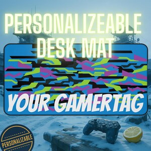 May include: A personalized desk mat with a blue background and a colorful geometric pattern. The text "PERSONALIZEABLE DESK MAT YOUR GAMERTAG" is displayed. A game controller and a lemon are in the foreground.