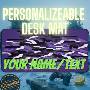 May include: A purple desk mat with a camouflage pattern in shades of purple, black, and white. The mat features the text "PERSONALIZABLE DESK MAT" and "YOUR NAME/TEXT" in bright green. A circular "PERSONALIZABLE" badge is in the lower left.