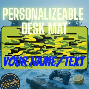 May include: A personalized desk mat with a camouflage pattern in shades of green, yellow, and black. The text "PERSONALIZABLE DESK MAT" is at the top, and "YOUR NAME/TEXT" is at the bottom. A controller and a lemon are in the foreground.