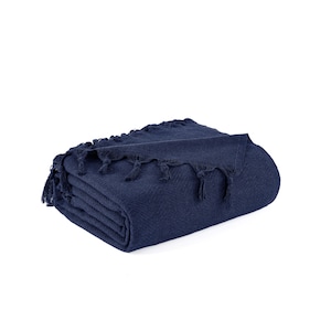 May include: A navy blue throw blanket with a herringbone pattern and fringe trim.