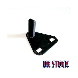 Puede incluir: Un soporte de plástico negro impreso en 3D con una base triangular y un poste vertical. El soporte tiene dos pequeños agujeros en la base.