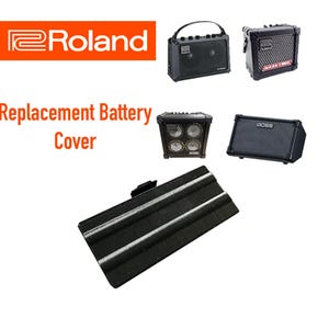 May include: Black replacement battery cover for a Roland guitar amplifier. The cover has a textured surface and is designed to fit the amplifier's battery compartment.