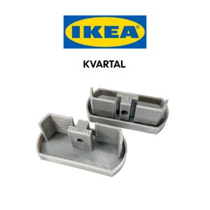 May include: Two gray plastic brackets with a hole in the center. The brackets are labeled "KVARTAL" and are from IKEA.
