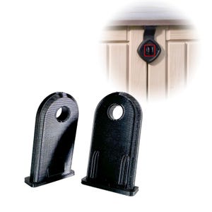 Op de afbeelding: Twee zwarte kunststof deurstoppers met een gat in het midden. De deurstoppers zijn ontworpen om te voorkomen dat deuren dicht slaan.