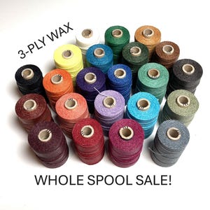 May include: A collection of twenty-two spools of 3-PLY WAX thread in various colors including yellow, orange, red, purple, blue, green, brown, gray, and black. Each spool has a cardboard core. The text 3-PLY WAX and WHOLE SPOOL SALE! is visible.