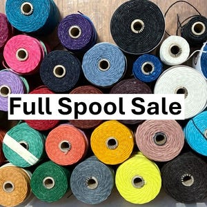 May include: A collection of multi-colored thread spools arranged in a container, featuring a variety of hues including red, blue, yellow, green, purple, black, and white. The text "Full Spool Sale" is overlaid in the center of the image.