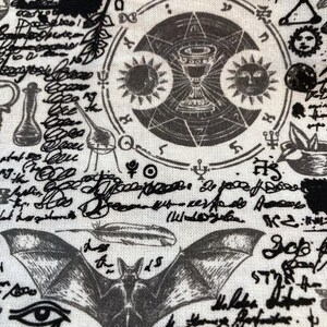 May include: A white fabric with a repeating pattern of occult symbols, including a chalice, suns, a bat, and script. The design is in black and gray, creating a gothic or mystical aesthetic. The overall theme suggests a focus on esoteric or spiritual concepts.