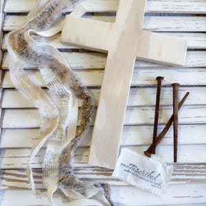 May include: A white ceramic mug with a black handle and the text "But First, Coffee" in a bold, black font. The mug is filled with a dark liquid, likely coffee, and sits on a light-colored surface.