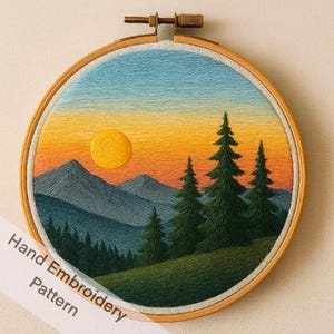 Pode incluir: Arte de paisagem bordada à mão em um bastidor de madeira. A cena retrata um pôr do sol com um sol amarelo, montanhas e árvores perenes. O céu transita do azul para o laranja. O texto "Hand Embroidery Pattern" é visível.