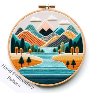 May include: A hand-embroidered hoop art piece depicting a colorful landscape with mountains, a river, and trees. The mountains are a mix of blue, green, orange, and gray. The river is a bright blue with white stitching. The trees are green and brown. The hoop is made of wood and has a natural finish.