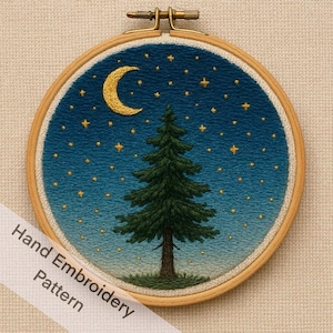 May include: Hand-embroidered night scene in a wooden hoop. The design features a crescent moon, a fir tree, and numerous stars against a gradient blue background. The text "Hand Embroidery Pattern" is on a white ribbon.