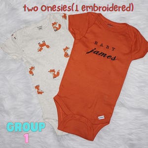 Puede incluir: Dos bodies de manga corta para beb&eacute;. Uno es de color crema con un patr&oacute;n de zorros naranjas. El otro es de color naranja s&oacute;lido con el texto bordado en negro "BABY james" centrado en el pecho. Aparece el texto "two Onesies(1 embroidered)" y "GROUP 1".