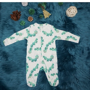 May include: White baby onesie with a green caterpillar print. The onesie has a zipper closure.