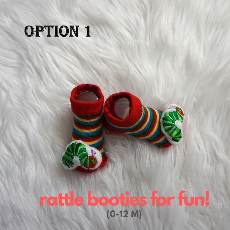May include: Red and yellow striped baby booties with a green caterpillar design. The booties have a rattle inside. The text "OPTION 1" and "rattle booties for fun! (0-12 M)" is visible in the image.