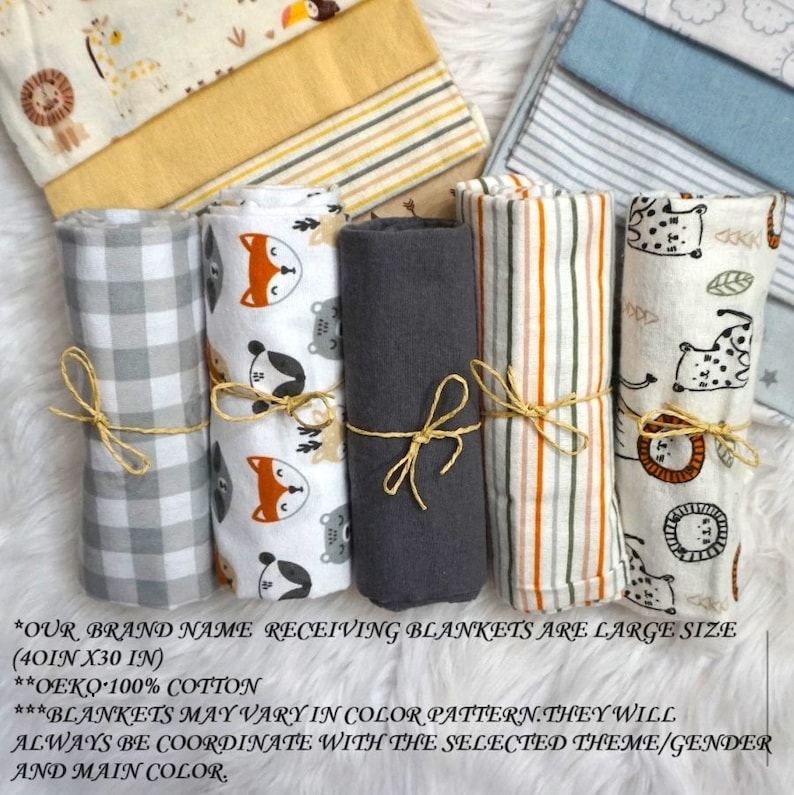 May include: Six rolled receiving blankets in various patterns and colours. The blankets are made of 100% cotton and are 40 inches by 30 inches. The patterns include a grey and white gingham, a white background with red foxes and other animals, a solid grey, a white background with orange and brown stripes, and a white background with orange and brown lions and other animals.