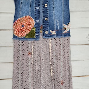 May include: A denim vest with embroidered flowers and a gray crochet skirt with a lace trim. The vest has a "maurices" label on the front.