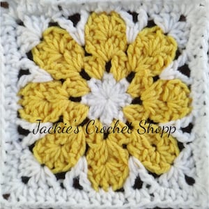 May include: A crochet square with a yellow flower in the center. The flower has six petals and a white center. The square is surrounded by a white border.