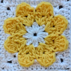 May include: A crochet square with a yellow flower in the center. The flower has five petals and a white center with a black button in the middle. The square is made with white yarn and has a black border.