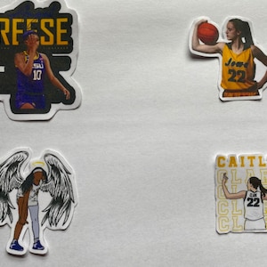 May include: Four stickers featuring female basketball players. The first sticker features a player in a purple jersey with the text "Reese" above her. The second sticker features a player in a yellow jersey with the text "Iowa 22". The third sticker features a player with angel wings and a halo. The fourth sticker features a player in a white jersey with the text "Caitlin Clark" repeated multiple times.