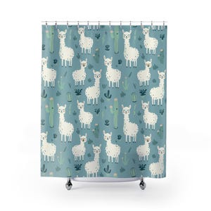 May include: A shower curtain featuring a repeating pattern of white llamas and green cacti on a teal background. The llamas have smiling faces and are interspersed with stylized cacti and other desert plants. The curtain is hanging from a metal rod.