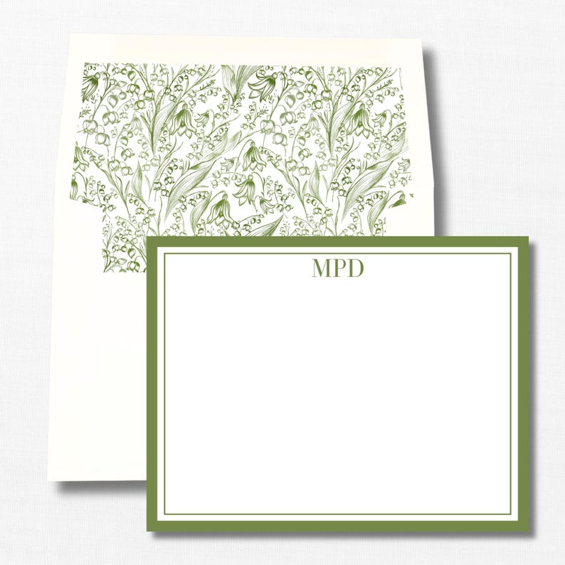 May include: A white card with a green border and a green floral pattern on the envelope. The card has the initials 'MPD' printed in the center.