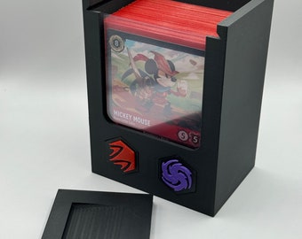 May include: Black card storage box with a clear window showing a red and white card with a cartoon image of Mickey Mouse. The box has a lid and three colored icons on the front.