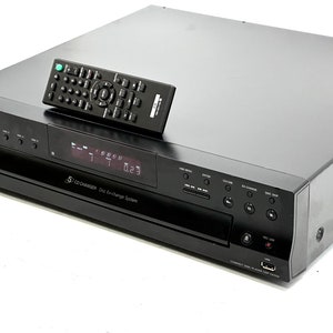 May include: Black Sony CD player with a remote control. The CD player has a digital display and several buttons for controlling the music. The remote control is black and has many buttons. The CD player is a 5-CD changer.