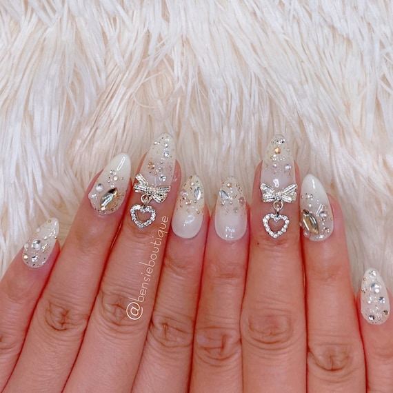 Nude acrylic nails with some stones and butterfly charms : r/AcrylicNails