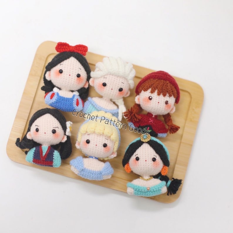 May include: Seven crocheted Disney princess dolls, including Snow White, Elsa, Ariel, Cinderella, Mulan, Jasmine, and Rapunzel. Each doll is handmade and features a unique design and color scheme.
