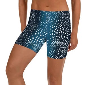 Puede incluir: Shorts deportivos con estampado azul y blanco. Los shorts tienen un fondo azul oscuro, cubierto de puntos blancos. Están hechos de un material elástico, adecuado para deportes y ejercicio.