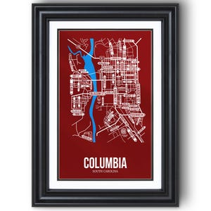 May include: Framed print featuring a detailed map of Columbia, South Carolina, with white street names and a blue river against a deep red background. The city name is prominently displayed in white at the bottom.