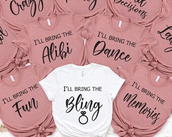 May include: Set of eight pink and white t-shirts with black text. Each shirt says "I'll bring the" followed by a different word. The words are: Alcohol, Crazy, Party, Bad Decisions, Alibi, Dance, Laughs, Fun, Bling, Memories.