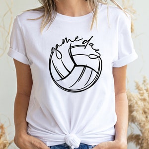 K&ouml;nnte beinhalten: Wei&szlig;es T-Shirt mit einer schwarzen Volleyballgrafik und dem Text "game day" in Schreibschrift.
